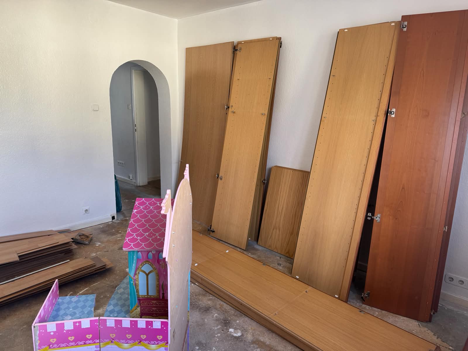 Wohnungsauflösung in Köln vorher – Zimmer mit abmontierten Schranktüren, Laminat und Spielzeug